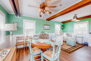 a dining room with green walls and a ceiling fan at Drehers Victory in Edisto Island