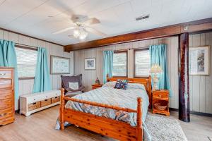a bedroom with a wooden bed and blue curtains at Drehers Victory in Edisto Island
