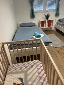 a baby crib in a room with a bed at Apartment CReO Loborika in Marčana