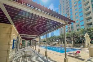 un dosel retráctil sobre una piscina en un complejo en LUXFolio Retreats - Astonishing 3BHk Apartment en Dubái