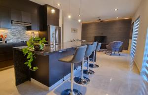 a kitchen with a bar with stools at Palacio Huatulco - 2I in Santa Maria Huatulco