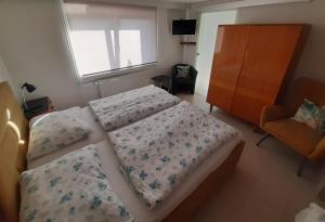 1 Schlafzimmer mit 2 Betten, einem Fenster und einem Stuhl in der Unterkunft Apartment Adéla in Hluboká nad Vltavou