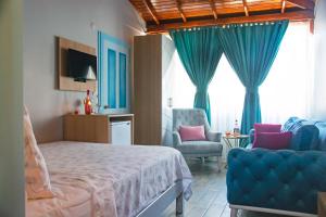 a bedroom with a bed and a blue chair and window at Çeşme Flowers Hotel in Ildır