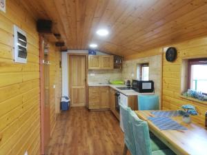 uma cozinha com paredes de madeira e uma mesa num camarote em Peace Creek em Slunj