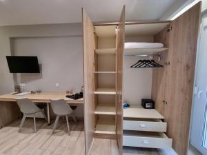 a room with a desk and a closet with shelves at Xanthi Apartments in Katerini