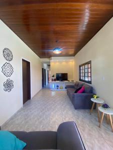 a living room with a couch and a table at Casa Paraíso - Cond Costa do Sol- Bertioga in Bertioga