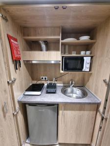 a small kitchen with a sink and a microwave at Xanthi Apartments in Katerini