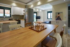 a kitchen and living room with a wooden table with chess at Palaiomylos Kos by Ktima Sfakia in Kos