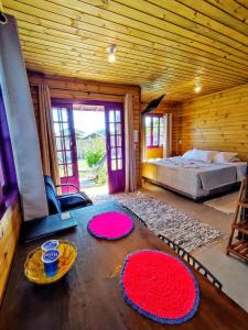 ein Schlafzimmer mit einem Bett und zwei Teppichen auf dem Boden in der Unterkunft Prana Guest House in Praia do Rosa