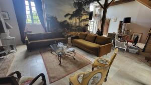 uma sala de estar com sofás, uma mesa e cadeiras em Manoir de La Garaye - Suite Parentale em Taden