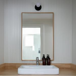 lavabo en el baño con un espejo grande encima. en Bluebird Ocean Point Inn, en Ocean Point