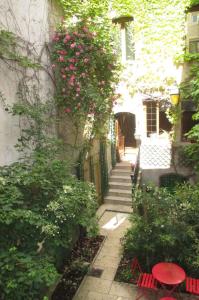 a garden with pink flowers on a building at Chambres d'hôtes Le Patio d'Alain et Véronique Lunéville in Lunéville