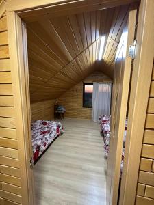 una camera con due letti in una casa di legno di Guest House Godogani a Godogani