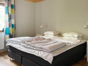 łóżko z białą pościelą i poduszkami w sypialni w obiekcie Holiday home KLINTEHAMN II w mieście Klintehamn