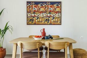 スコペロスにあるYianna Sunny Studiosのダイニングテーブル(椅子付)が備わります。壁には絵画が飾られています。