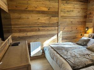 a bedroom with a bed and a wooden wall at Le cerf majestueux, Bolquere in Bolquere Pyrenees 2000