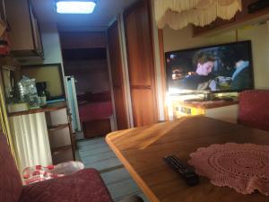 a living room with a table and a tv on the wall at LappHouse Puistola in Palojoensuu