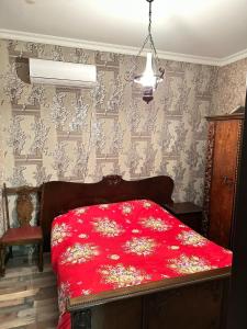 een slaapkamer met een rood dekbed op een bed bij Guest House Godogani in Godogani