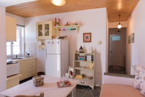 a kitchen with a white refrigerator and a table at Geronti Moscha Apartment in Apollonia