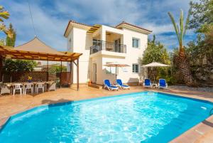 a villa with a swimming pool and a house at Villa Kleopatra in Paphos