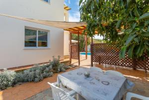 a patio with a white table and white chairs at Villa Kleopatra in Paphos