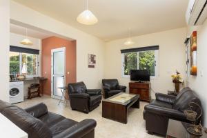 a living room with leather furniture and a tv at Villa Kleopatra in Paphos