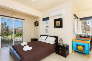 a bedroom with a bed and a large window at Villa Kleopatra in Paphos +31 photos
