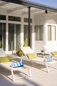 a group of lounge chairs sitting on a patio at The Three Fifty Hotel, A Kirkwood Collection Hotel in Palm Springs