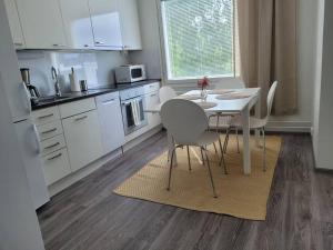 a kitchen with a table and chairs in a kitchen at Wäinönkatu 3 yksiö in Lappeenranta