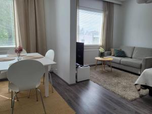 a living room with a white table and a couch at Wäinönkatu 3 yksiö in Lappeenranta