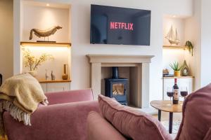 a living room with a couch and a fireplace at Canon Craig, Luxurious Lakeland stone Cottage in Bowness-on-Windermere +22 photos