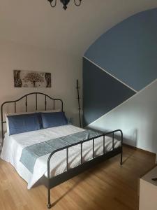 a bedroom with a bed with blue pillows at Greta's Home a 2 minuti dal lago in Arona