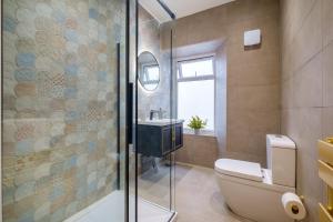 e bagno con doccia, servizi igienici e lavandino. di Canon Craig, Luxurious Lakeland stone Cottage a Bowness-on-Windermere