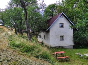 ein Haus mit einem Picknicktisch davor in der Unterkunft chaloupka Karolinka in Karolinka