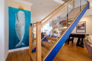 a blue staircase in a home with a whale painting on the wall at Canon Craig, Luxurious Lakeland stone Cottage in Bowness-on-Windermere