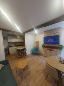 a living room with a television and a table and chairs at Maison de rue: Auch in Auch +10 photos