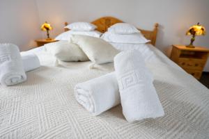 un grupo de toallas blancas en una cama en White Dove Pension, en Miercurea-Ciuc