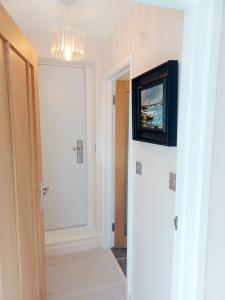 a room with a television on a wall with a door at The Little Limes - Ensuite Double Room Own Entrance in Art Deco House in Kent