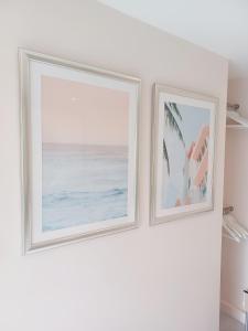 zwei gerahmte Bilder des Ozeans an einer Wand in der Unterkunft The Little Limes - Ensuite Double Room Own Entrance in Art Deco House in Kent