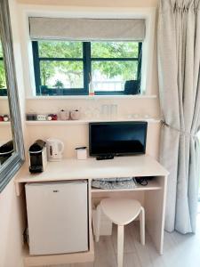 a computer desk in a room with a window at The Little Limes - Ensuite Double Room Own Entrance in Art Deco House in Kent