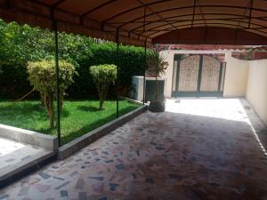 a courtyard with a gate and a yard with trees at location vacance sidi bouzid in Sidi Bouzid
