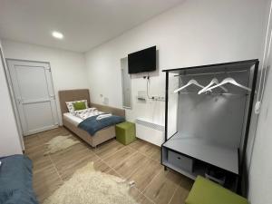 a small room with a bed and a mirror at Ravne Energy Apartments in Visoko