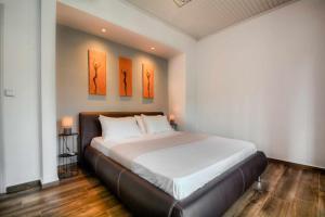 een slaapkamer met een bed met drie schilderijen aan de muur bij Stratos house! in Alepou