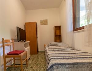 Dormitorio pequeño con cama y TV en Fredi, en Mali Lošinj