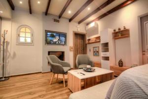 1 Schlafzimmer mit 2 Stühlen, einem Bett und einem TV in der Unterkunft Stratos house! in Alepou