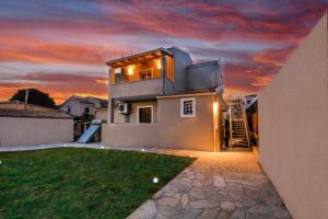 ein Haus mit Sonnenuntergang im Hintergrund in der Unterkunft Stratos house! in Alepou