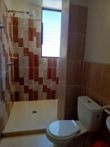 uma casa de banho com um WC e um chuveiro com uma janela em Jhonyximena em Copacabana