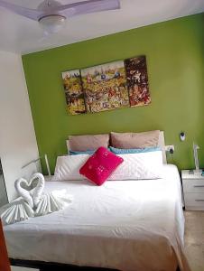 1 dormitorio con cama blanca y pared verde en RUIDERA HOLIDAY en Ruidera