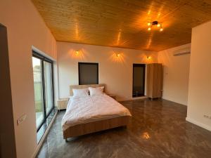 - une chambre avec un lit et un plafond en bois dans l'établissement ALEX’S BEACH HOUSE, à Corbu