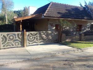 a fence in front of a house with a gate at "Mi Casa" in Villa General Belgrano